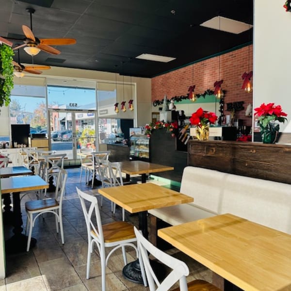 Interior of Best Artisan Empanadas with tables, chairs, and festive holiday decorations.